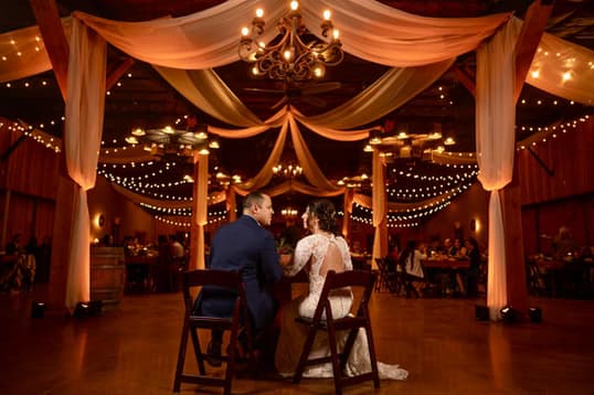 The draped pavilion glowing with chandeliers and string lights