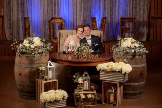 A styled sweetheart table with florals and marquee letters